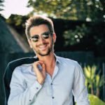 Confident young man in a stylish suit outdoors, exuding charm and elegance.
