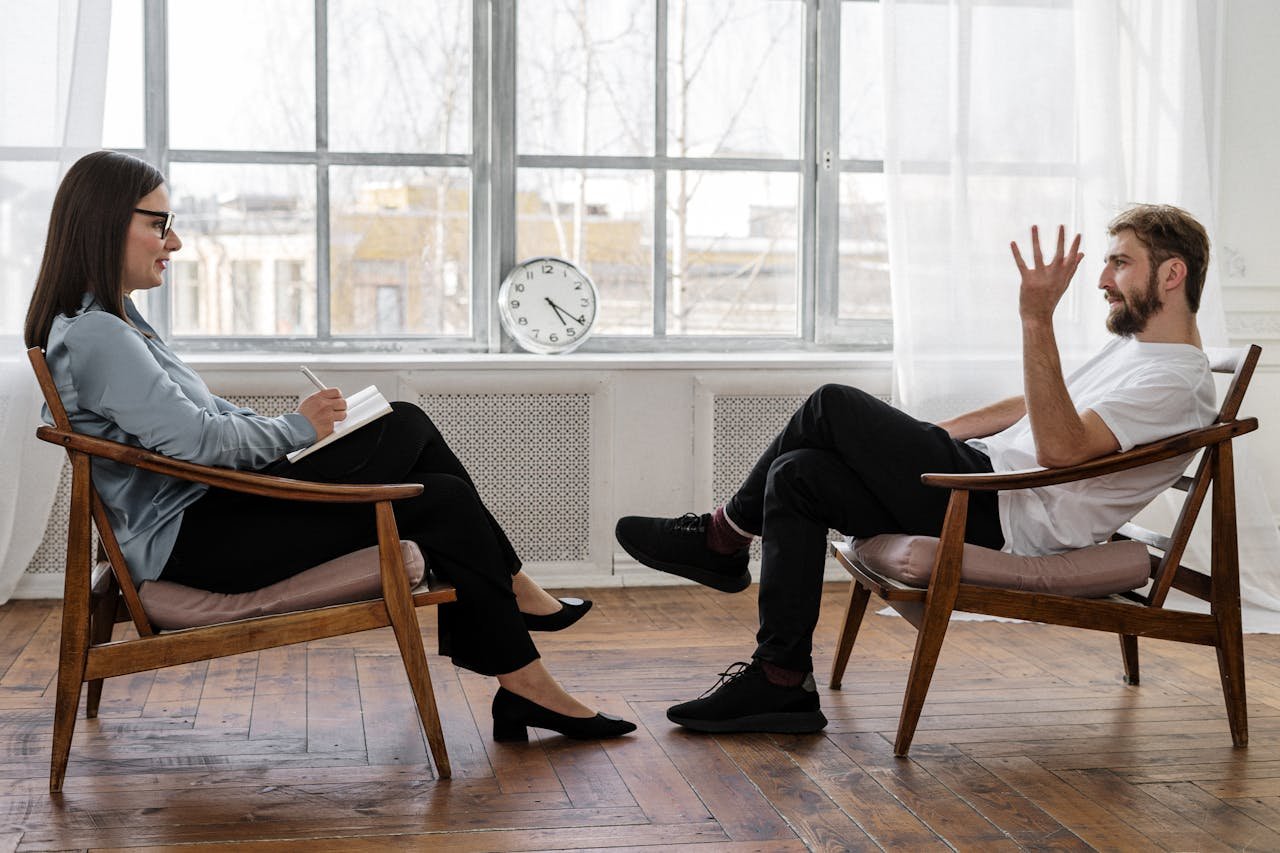 about-us-02 A therapist engaging in a counseling session with a male patient to support mental health.